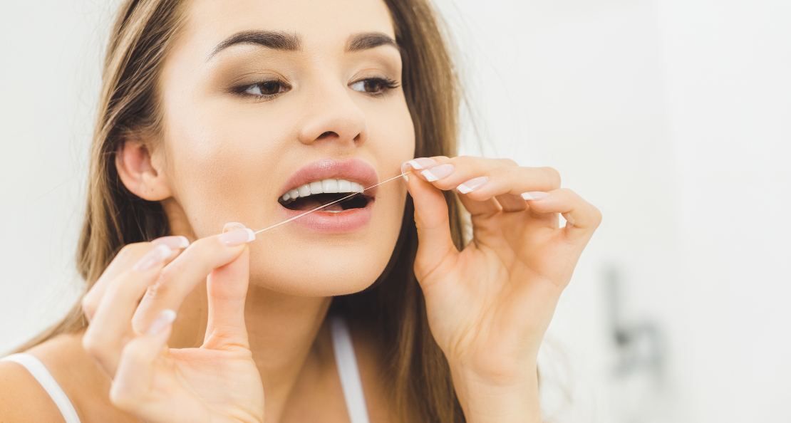 the photo shows a girl flossing her mouth with dental floss