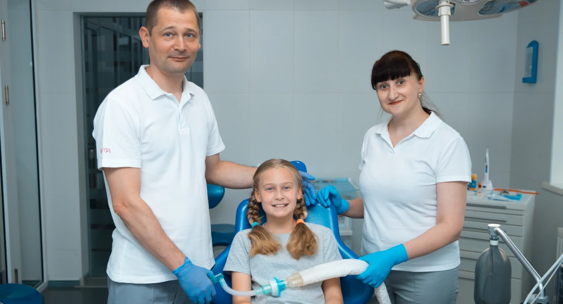 In the photo, a dental surgeon's office in Bagit's dental clinic, a little smiling girl in a chair after general anesthesia